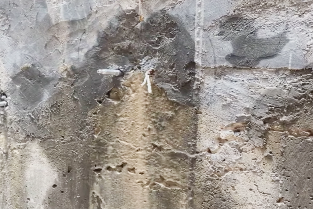 Water seeping through concrete water tank wall due to cracks and waterproofing failure